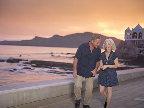 Pareja caminando por el malecón de Mazatlán al atardecer